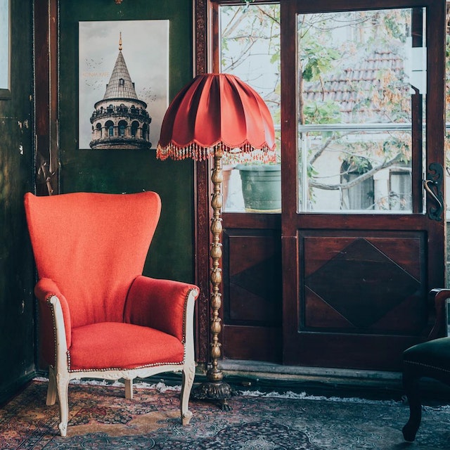 A picture of red chair beside a lamp