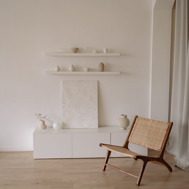 A brown wooden chair beside white wall